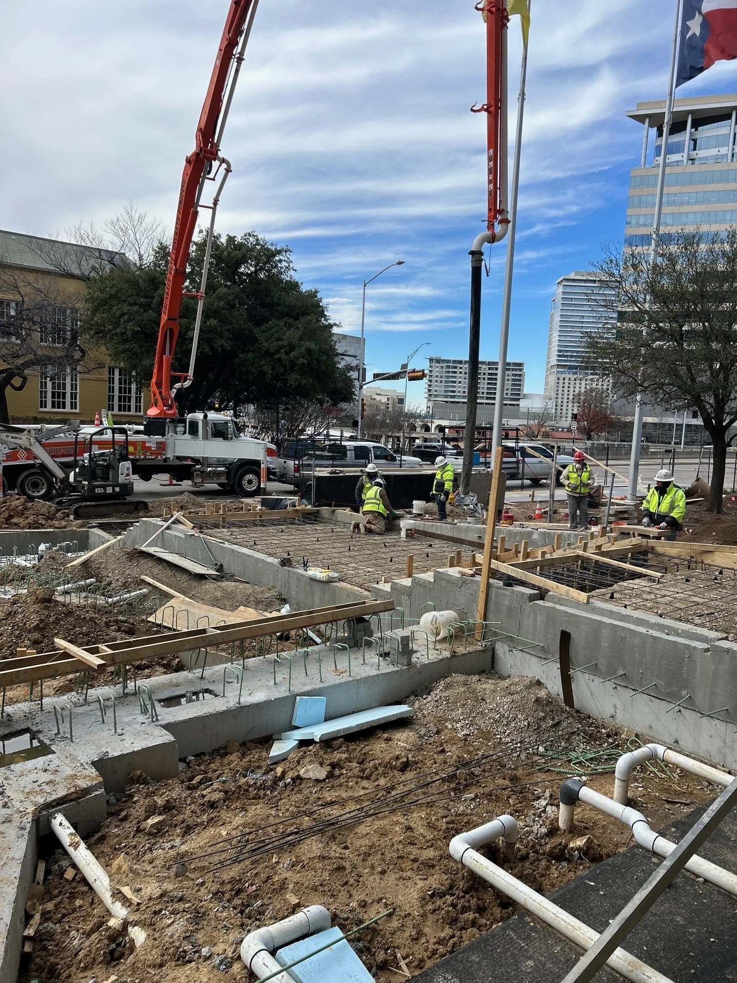 Trillium boom pump placing structural concrete on a downtown Dallas commercial build