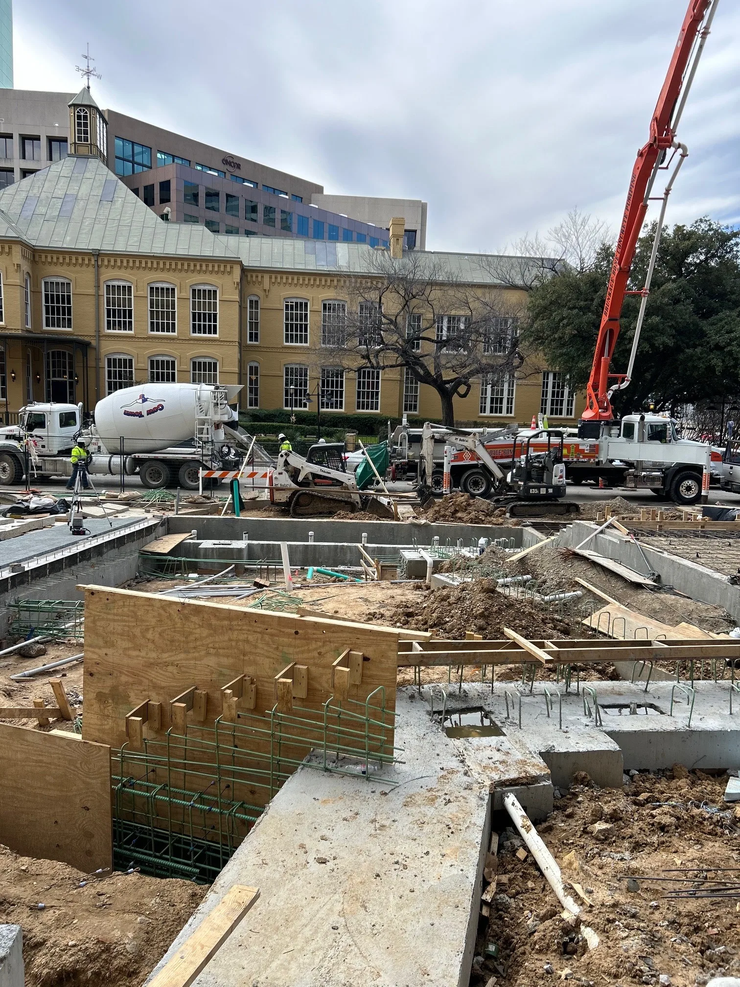 Mixer trucks and boom pump on a Trillium commercial concrete pour in downtown DFW